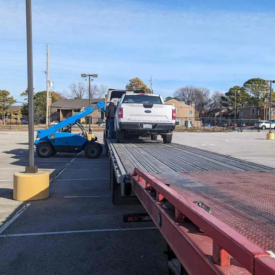 Towing service with a flatbed truck and wheel lift for vehicle recovery and roadside assistance.