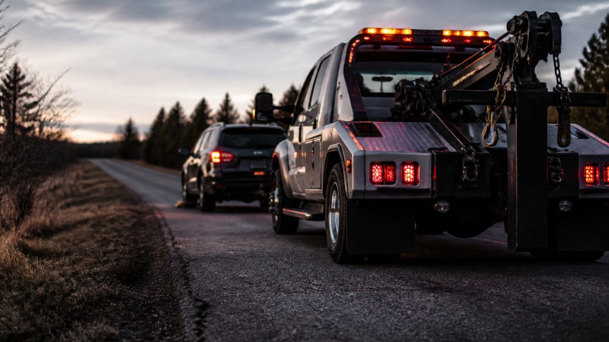 Diagram illustrating the proper alignment of tow trucks for damage-free vehicle recovery on a roadside.